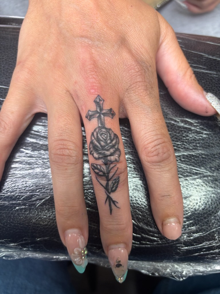 Rose and cross finger tattoo